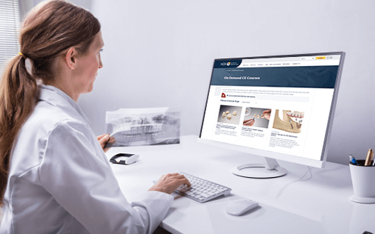 A female dentist watching a webinar put on by a dental lab serving the US and Canada