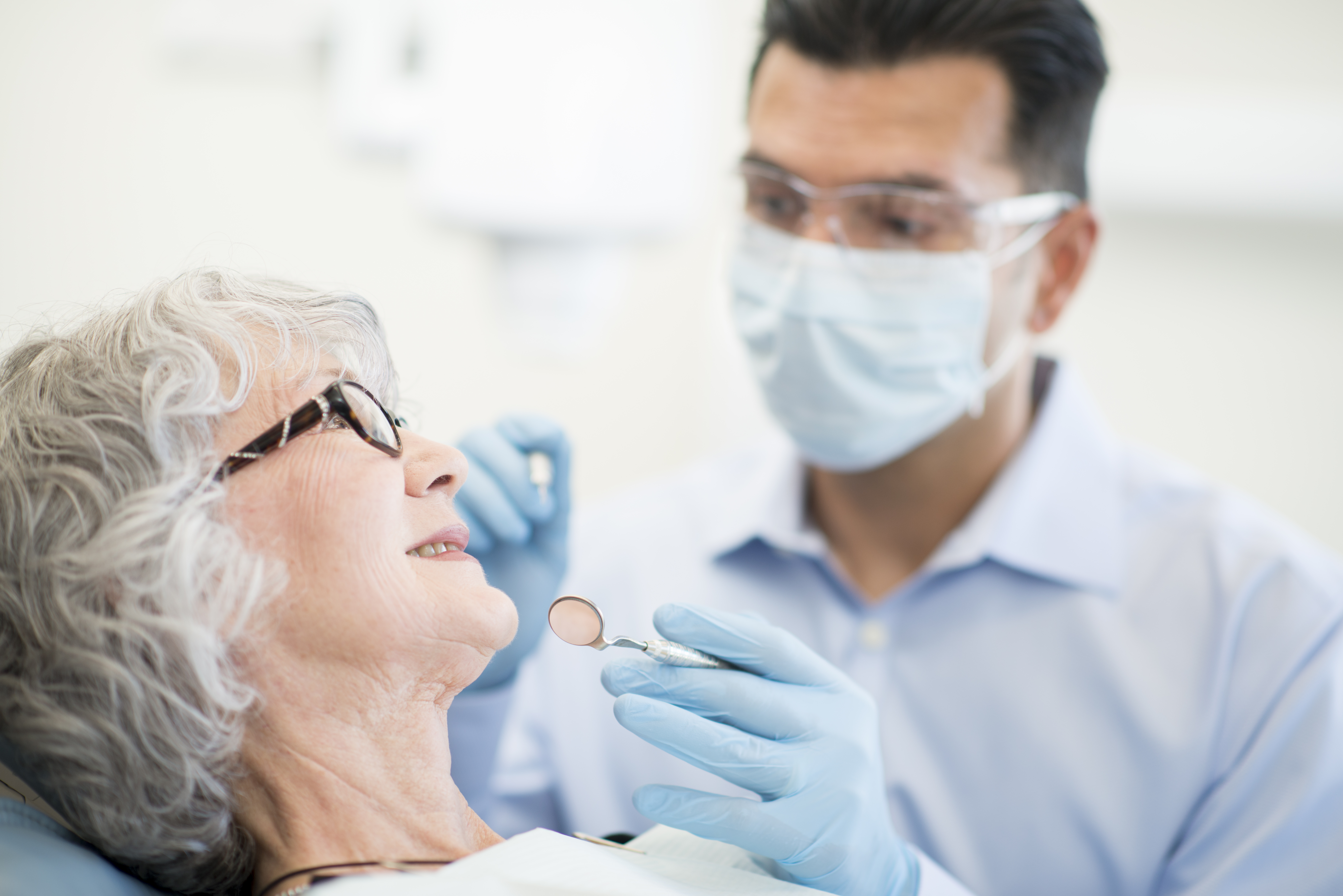 male dentist working on a female patient with equipment from a dental lab