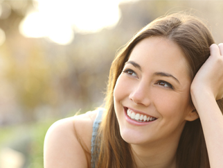 A woman with white teeth smiling after using her bleaching trays provided by a dental lab